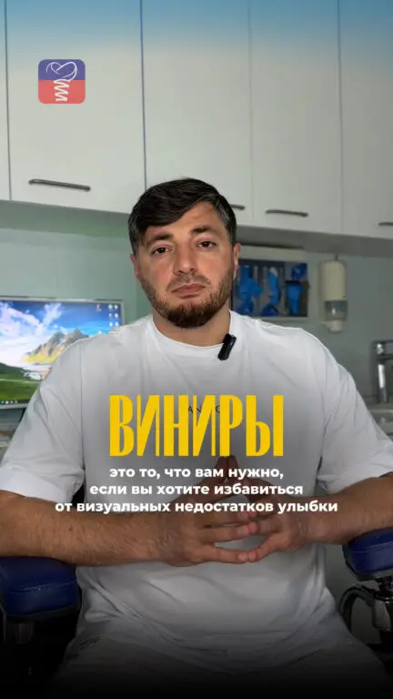 Стоматолог в кабинете смотрит в камеру и рассказывает о преимуществах керамических виниров.